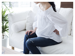 腰をおさえる女性